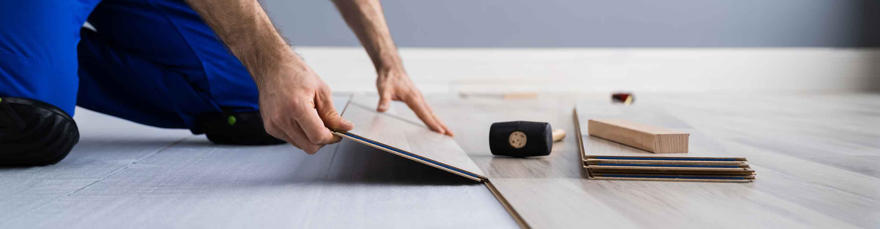 Human installing flooring with tools