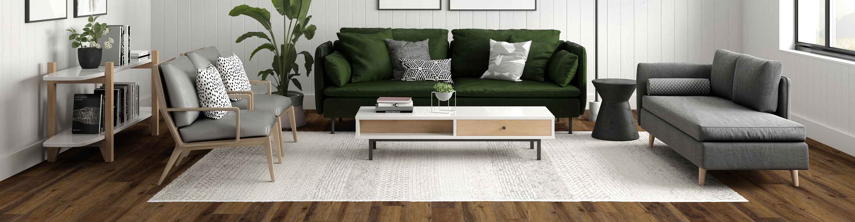 Modern living room with a dark green velvet sofa, light wood armchairs, a textured light rug, and stylish decor elements including plants and books.
